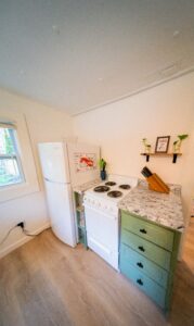 Compact kitchen with full-size refrigerator, electric stove, and ample counter space at Norma's Vacation Home in Stonington, Maine